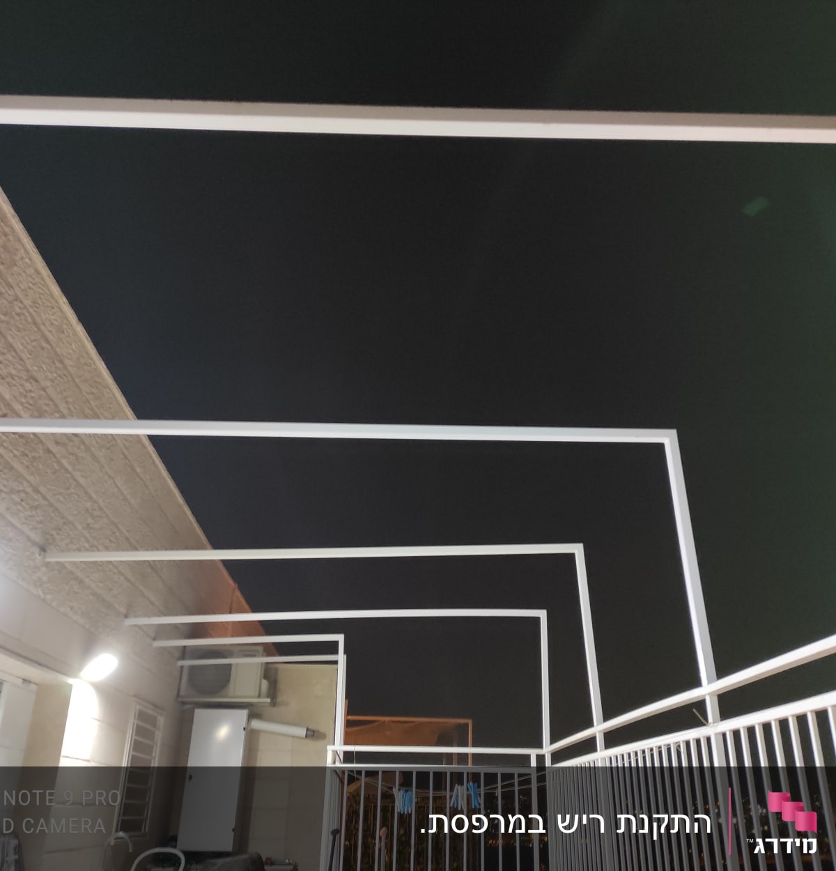 מסגרות מתכת לבנות על מרפסת בלילה